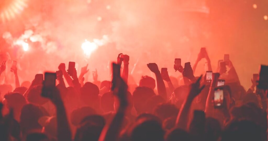 観衆が手を挙げてノッているライブ会場の写真