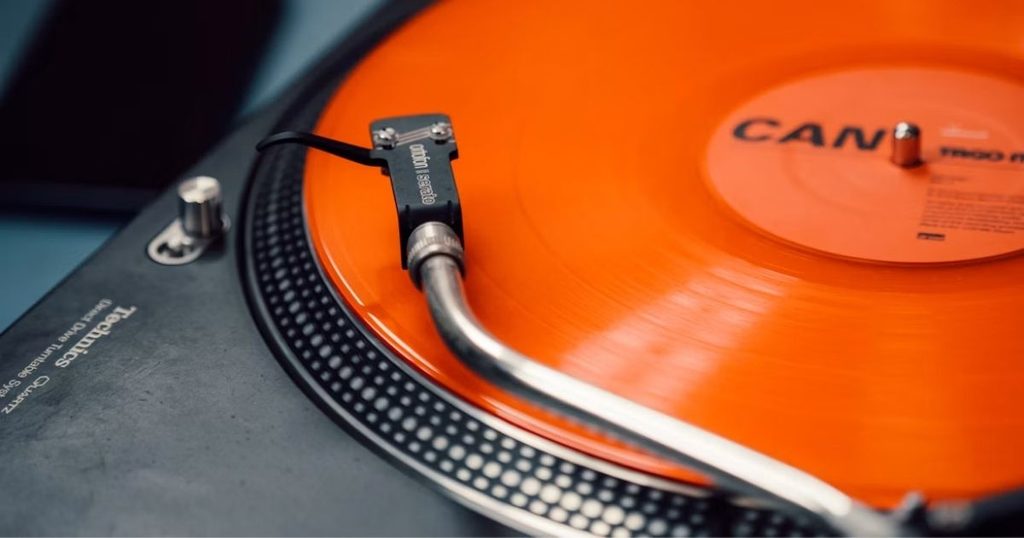 オレンジ色のレコード盤を再生するプレーヤーの写真