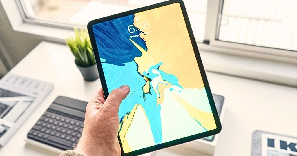 室内でタブレットを手に持っている写真